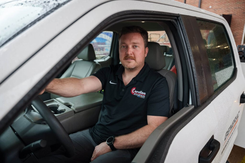 A Carolina Heating Service technician in the driver’s seat of a service truck - Carolina Heating Service Inc. A Carolina Heating Service technician in the driver’s seat of a service truck