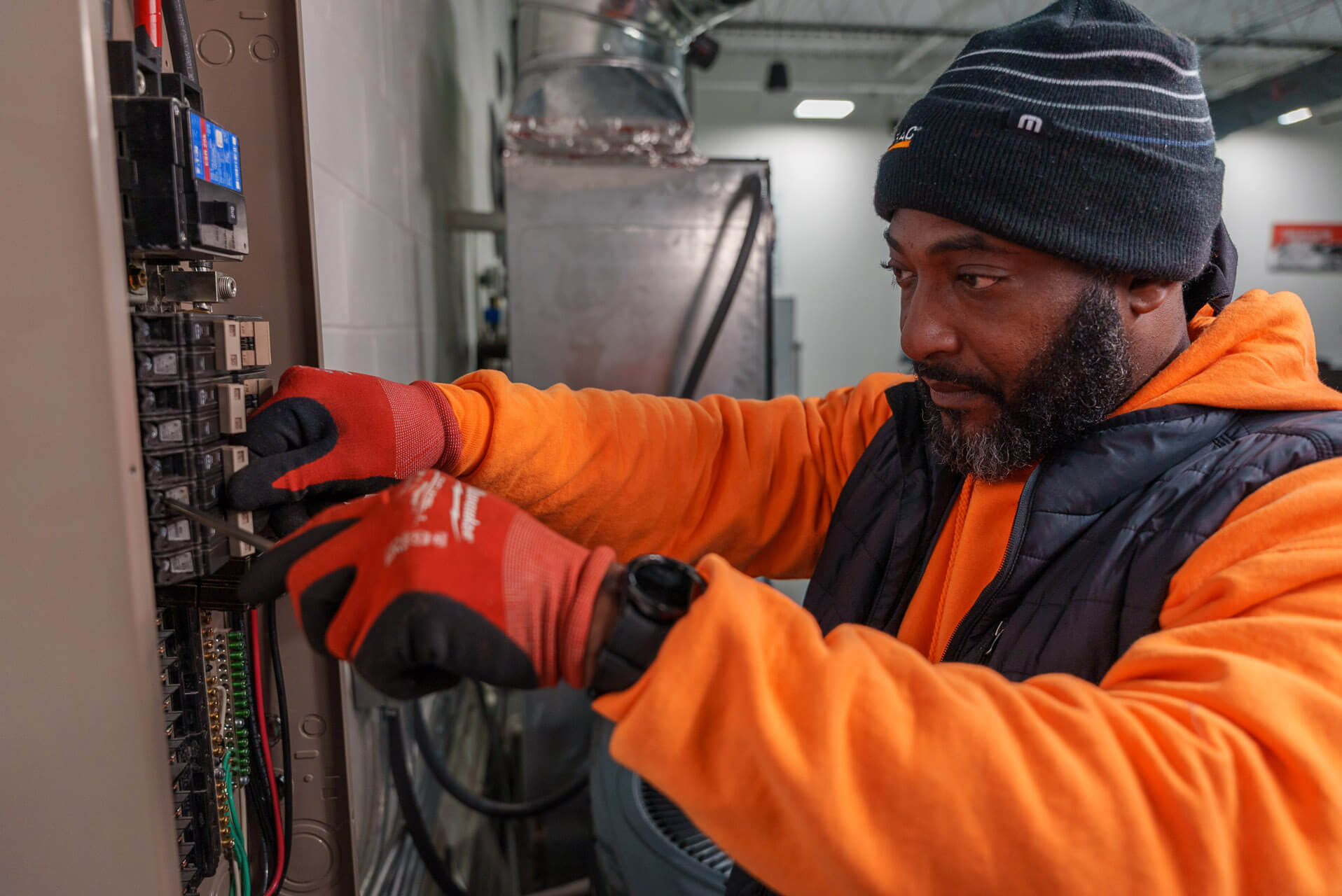 A Carolina Heating Service technician working on an electrical panel - Carolina Heating Service Inc. A Carolina Heating Service technician working on an electrical panel